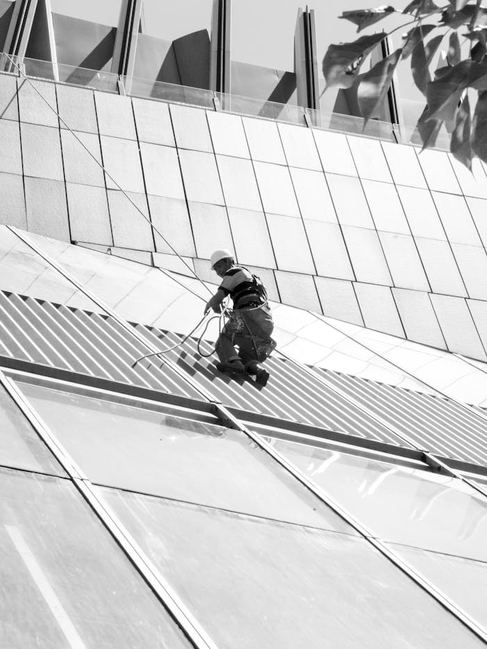 team-03 A window cleaner working on a modern architectural facade in black and white.
